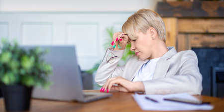 Close up photo of an exhausted woman working at home before the deadline.