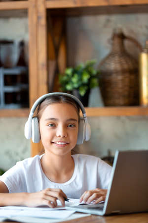 Online education concept - girl with headset during an online lesson. She sitthing in front of...
