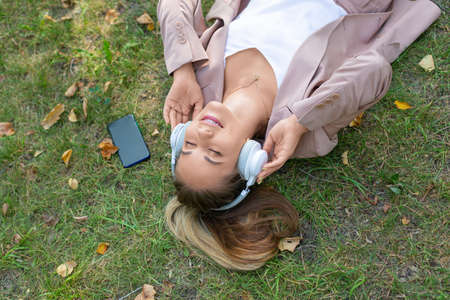 Close-up photo - woman in the grass enjoying the music.の写真素材