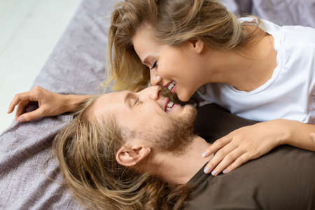 View from above. Loving couple in bed. They hug and kiss.の写真素材