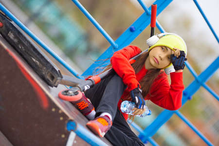 Photo of a ten-year-old girl is resting after riding a scooter.の写真素材