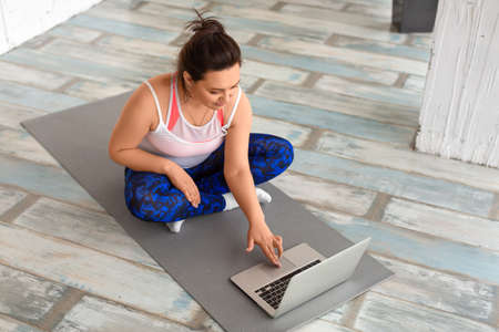 Photo of a middle aged woman prepares for online workout.の写真素材