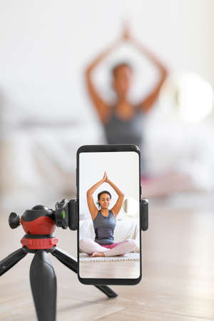 Yoga online to live streaming on a smartphone - vertical photo.の写真素材