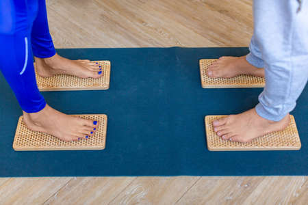 Close-up photo of a couples feet standing on Sahu boards with sharp nails.
