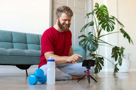 A middle-aged man searches the internet for an online home workout guide.の写真素材