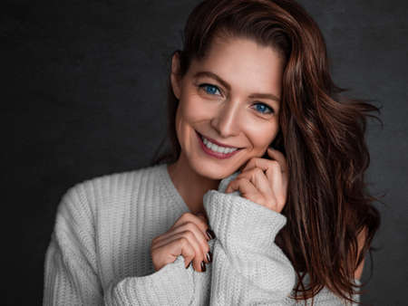 Smiling blue eyed 40 years old woman looking at camera - psychology and feminine health concept.