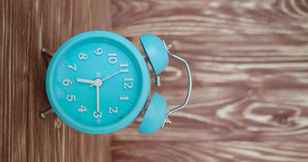 Vertical video with sound - white alarm clock on a wooden background rings at 6:15 AMの写真素材