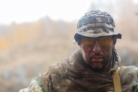 Portrait of a tired soldier with a dirty face. He looking at camera.の写真素材
