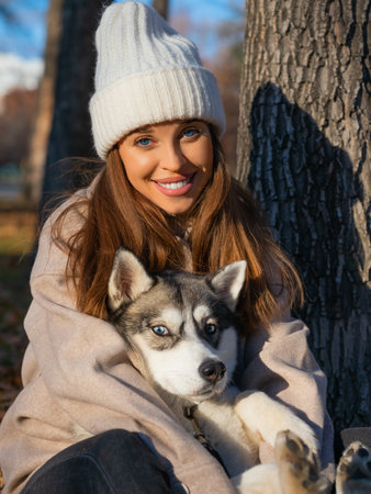 Young woman embracing her dog and looking at camera. Close-up vertical photo.の写真素材