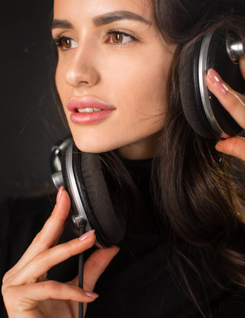 Close-up vertical portrait of a young woman with headphones.の写真素材