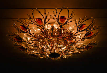 classic chandelier from glass hanging on the wooden ceilingの写真素材
