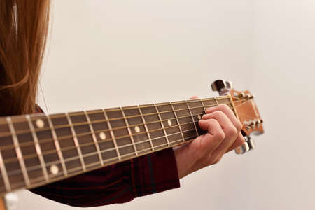 woman's hands playing acoustic guitar, close up. Playing acoustic guitar girl or woman with long...