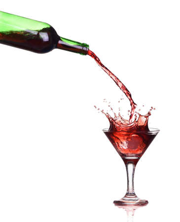 Red wine splash in the glass, pouring from a bottleの写真素材