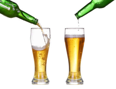 Beer is pouring into glass from bottle isolated on white background. Beer make splashの写真素材