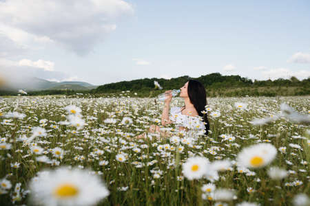 happy little girl in the chamomile field in springの写真素材
