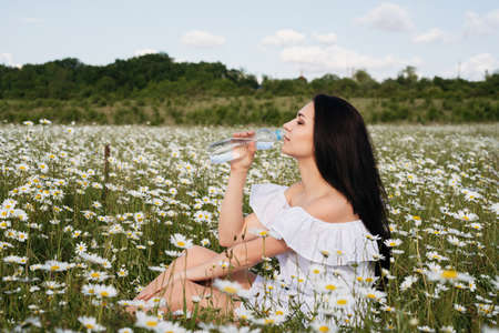 happy little girl in the chamomile field in springの写真素材