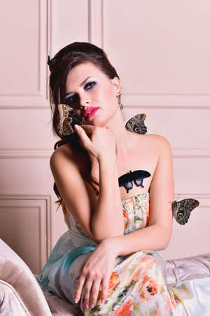 Attractive brunette girl with exotic tropical butterflies in studioの写真素材