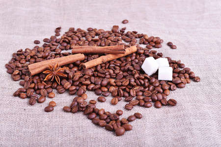 Brown coffee beans, cinnamon, sugar and star anise on the linen tableの写真素材