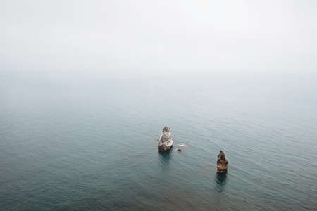 Rocks stick out of the sea. Seascape with fogの写真素材