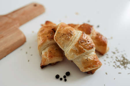 Homemade puff on the white table. Croissant with cheese and meat