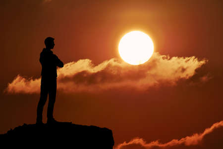 Silhouette of man at the top of the mountain on sunset. Beautiful landscape.