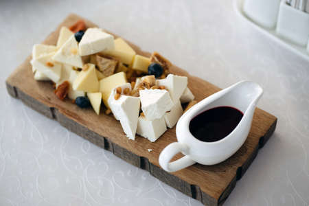 Mix cheese on wooden board with grapes. Top view.