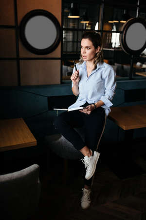 Pretty woman thinking and make records in daily planner. Casual style clothesの写真素材