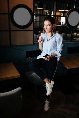 Pretty woman thinking and make records in daily planner. Casual style clothesの写真素材