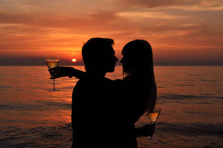 Silhouette of a couple in love on a sunset tropical background.の写真素材