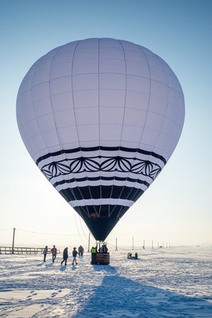 boarding on a balloon on a frosty winter day. background white endless desert with snow. copyspace.の写真素材