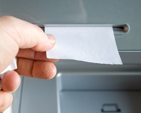 a man takes a check issued by an ATM, a check without inscriptions, a place for the text on the check. mock -up.の写真素材
