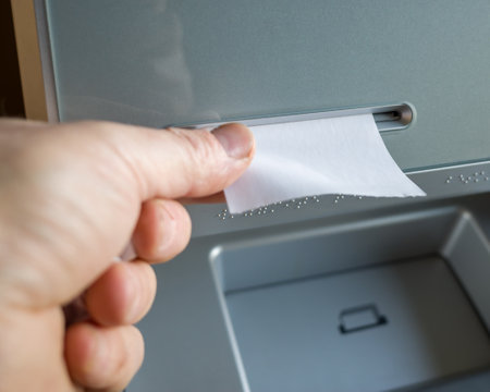a man takes a check issued by an ATM, a check without inscriptions, a place for the text on the check. mock -up.の写真素材