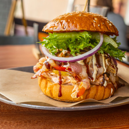 a large hamburger on a wooden table in a cafeの写真素材