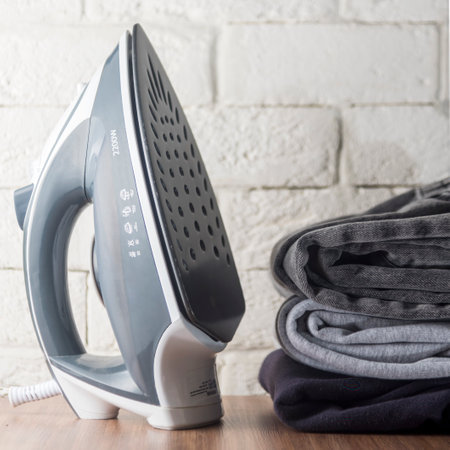 iron for ironing clothes on the background of a white brick wall. copyspace.の写真素材