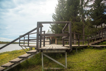 a wooden staircase going up the hill. country house, outdoor recreation. early morning, glowy sky.の写真素材