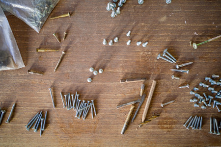 screws and self-tapping screws of various lengths on a wooden table. close-up.の写真素材