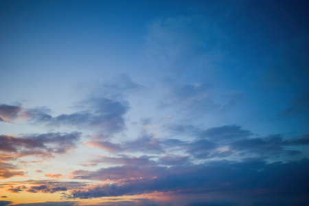 blue sky with clouds and the setting sun