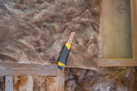 construction knife for cutting insulation for laying in a frame house under construction. natural lightの写真素材