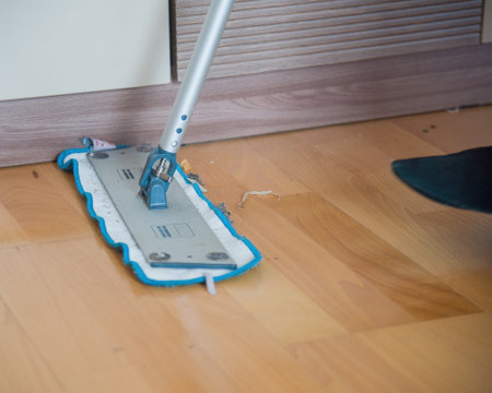 Washing the parquet floor with a mop in the apartment. Routine house chores concept. copy space.の写真素材
