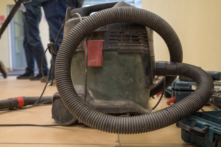 An industrial vacuum cleaner on a dusty floor in a building under construction and renovation. close-upの写真素材
