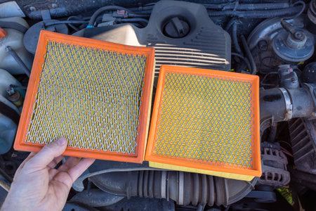 A new and old dirty car engine air filter in the hands of an auto mechanic. The concept of car maintenance.の写真素材