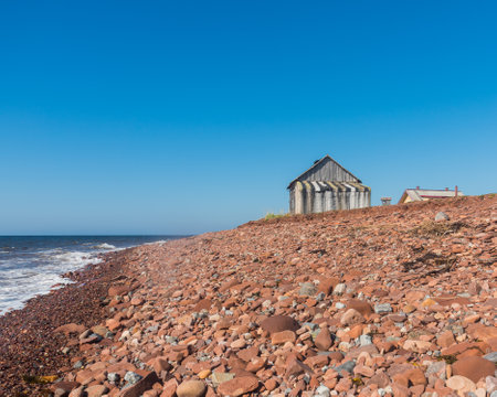 a lonely wooden house blown by all the winds on the seashore in the northの写真素材