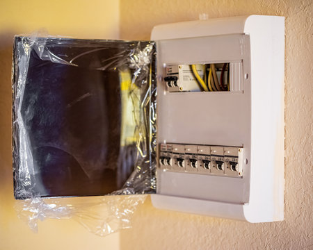 a new electric switchboard with electric circuit breakers in a white case in the apartment of a new...