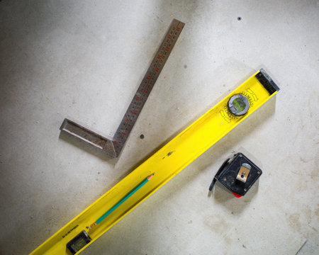 various measuring objects ruler tape measure level on the cement floor. construction and renovation