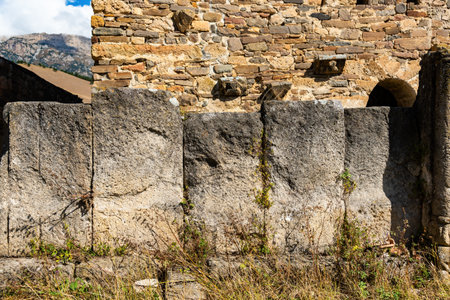 a very old and ancient fence of large powerful stones behind which there is a stone ancient structure. copy spaceの写真素材