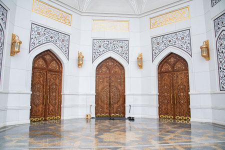 Wooden entrance gate to the mosque in front of one of the gates in front of the entrance lies shoesの写真素材