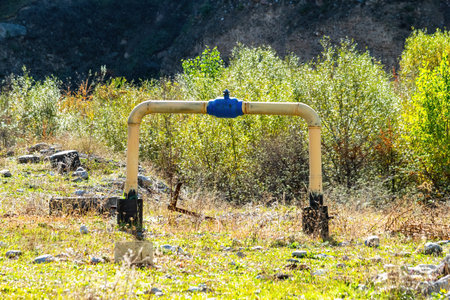 Old yellow gas pipe with a faucet in the mountain areaの写真素材