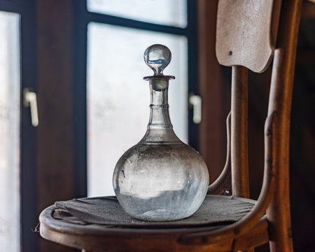 Old Vintage Glass Decanter on a wooden chair. Antique Object.の写真素材