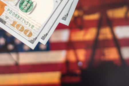 hundred US dollars in front of an out of focus American flag