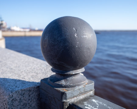 Dark sphere on a railing overlooking water. Waterside Finialの写真素材